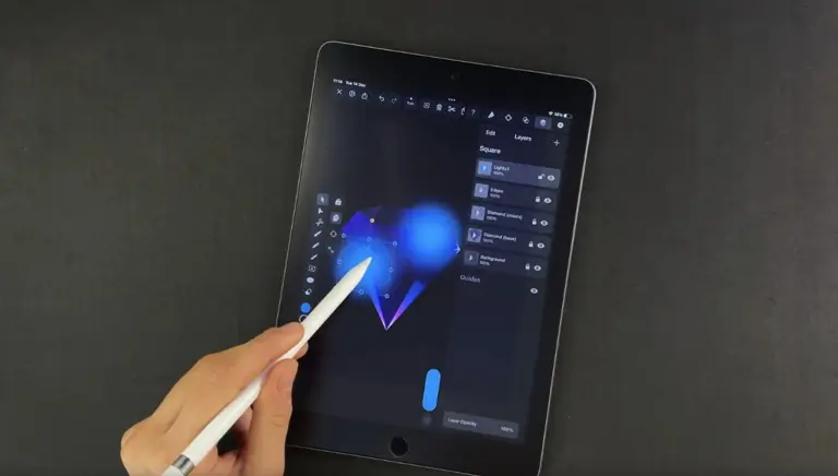 Hand holding a stylus to a tablet with graphic design software open, lights effect on a geometric shape