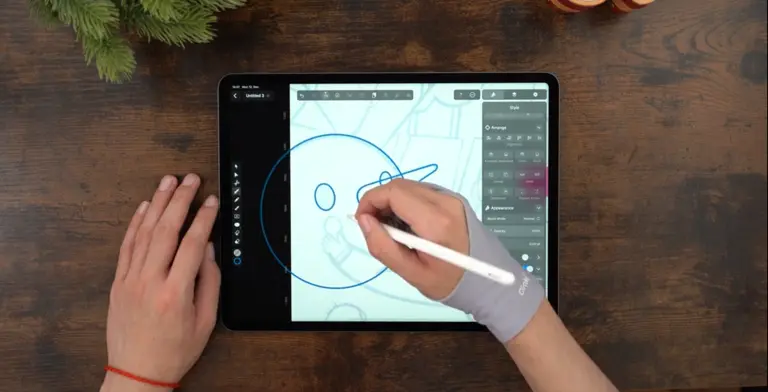 Male hands drawing on an iPad positioned on a wooden table