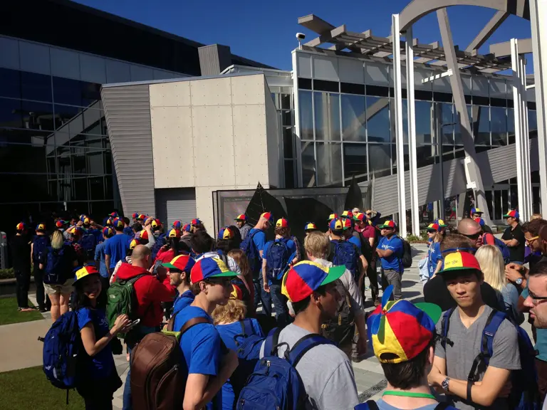 Group of people with Google caps in front of the Google headquarter