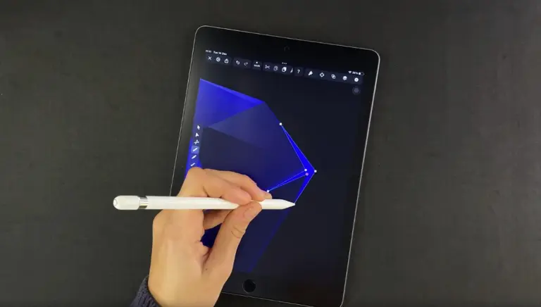 Hand holding a stylus to a tablet screen displaying geometric shape editing