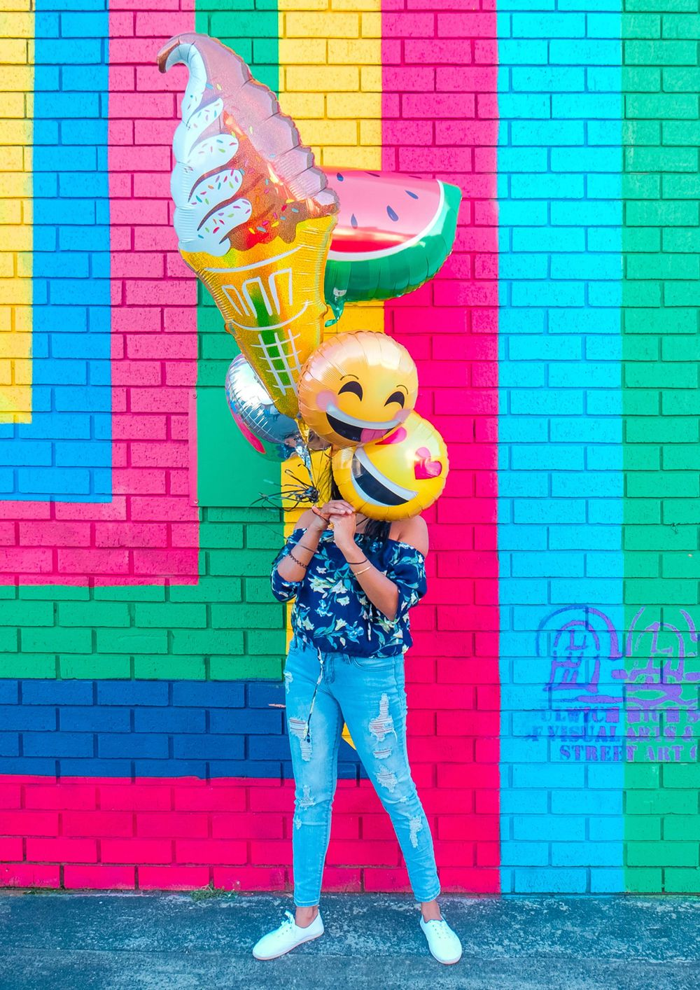 Colorful wall with a girl holding balloons