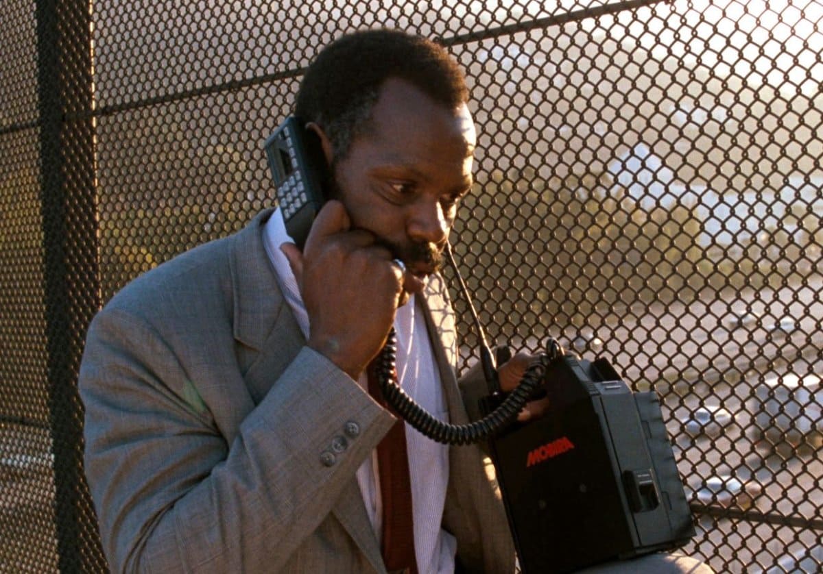 Black man using a portable 80s phone