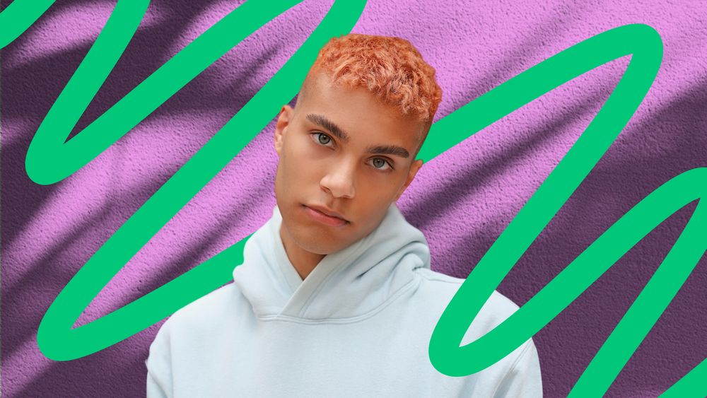 Individual with orange hair in front of a purple and green graphic background