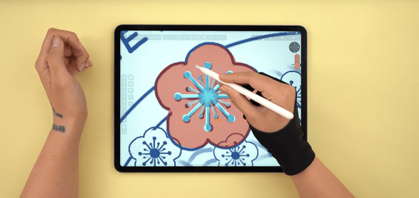 Close-up of a hand illustrating a flower on a digital drawing tablet