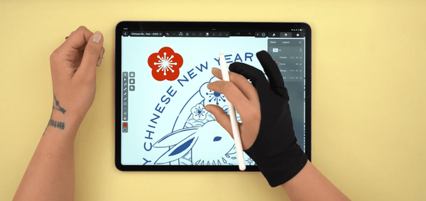 Hand drawing on a tablet with "CHINESE NEW YEAR" text and red flower