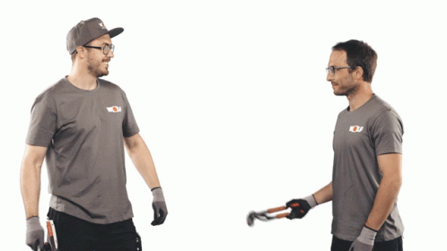  Two people exchanging a tool in matching t-shirts and caps